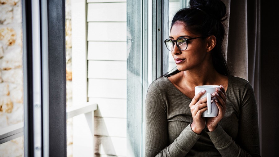 woman sitting at window with coffee