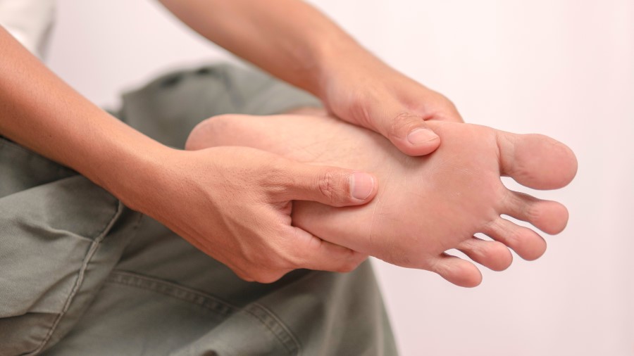 close up of foot and hands being used to massage the soles of the feet