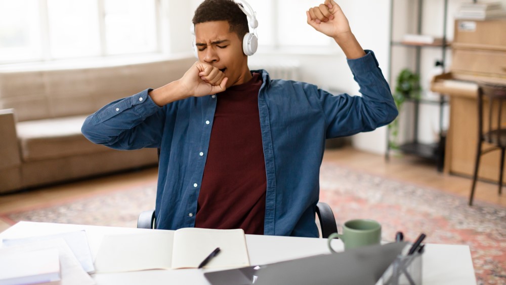 Teen boy yawning teen boy yawning over homework