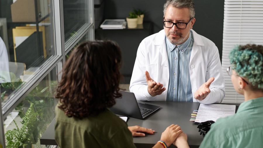 doctor talking to lesbian couple doctor with lesbian couple